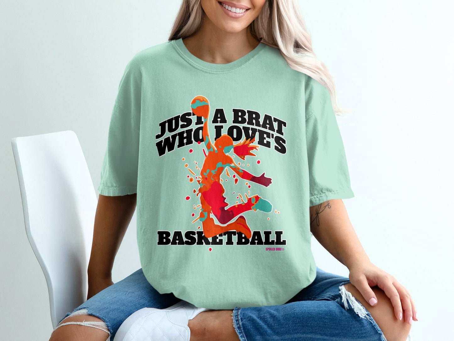 Mint t-shirt with orange splatter basketball graphic and text.