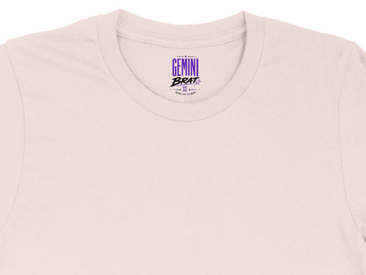Light pink t-shirt with "Gemini Brat" graphic and astrological symbol.