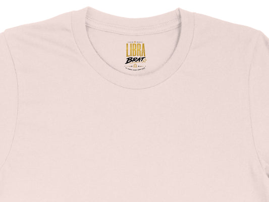 Pink t-shirt with gold "Libra Brat" logo and astrological symbols.
