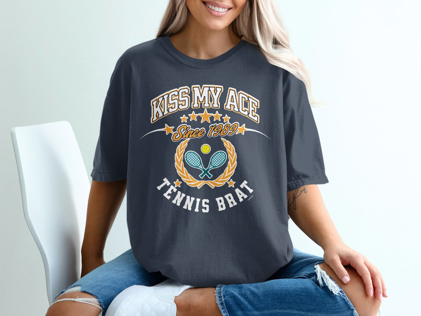 Dark gray t-shirt with "Kiss My Ace Since 1989 Tennis Brat" graphic.