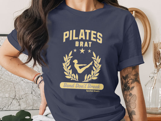 Dark navy t-shirt with yellow "Pilates Brat" graphic and "Bend Don't Break" text.