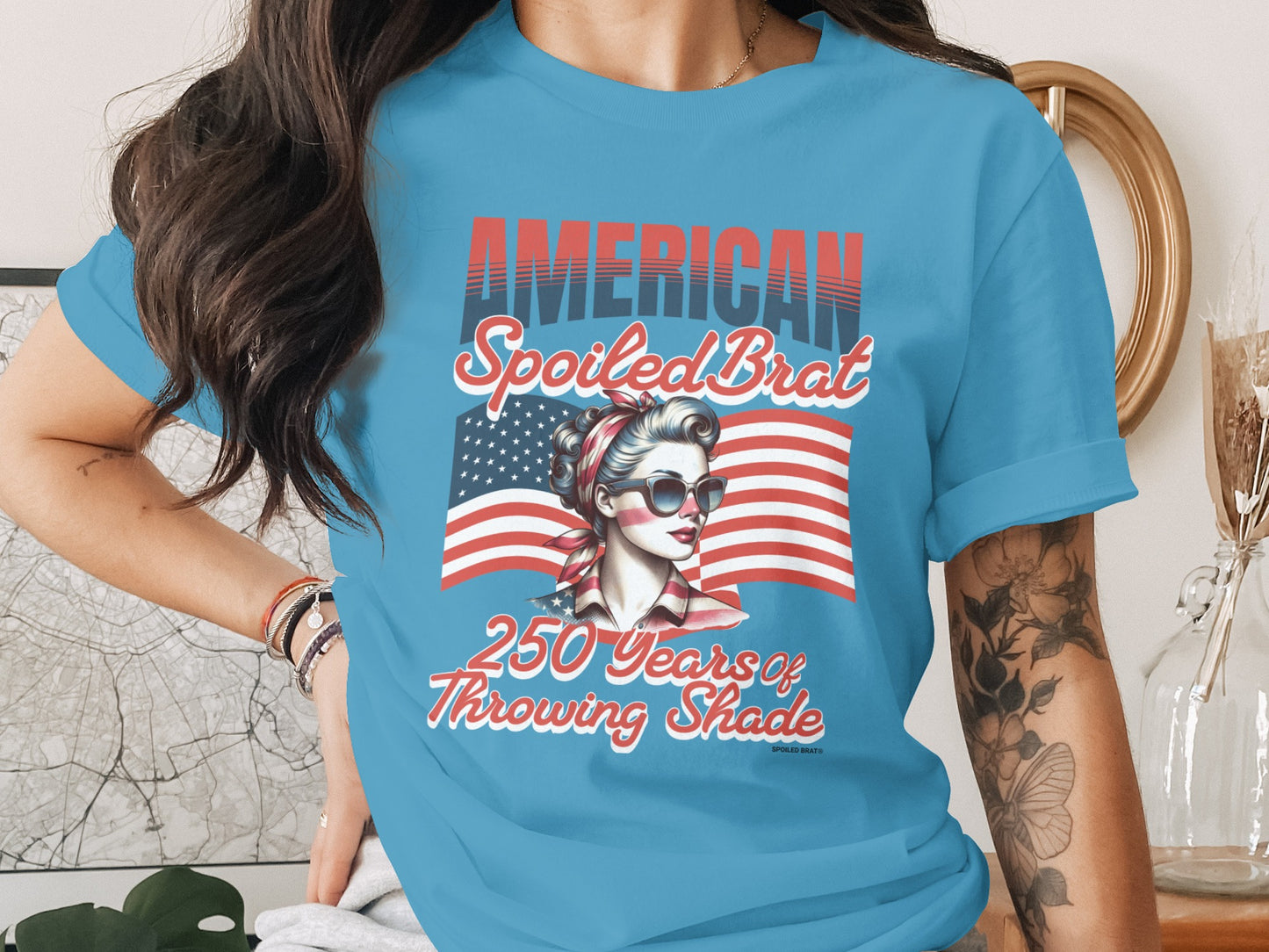 American Spoiled Brat graphic tee with American flag and woman wearing sunglasses.