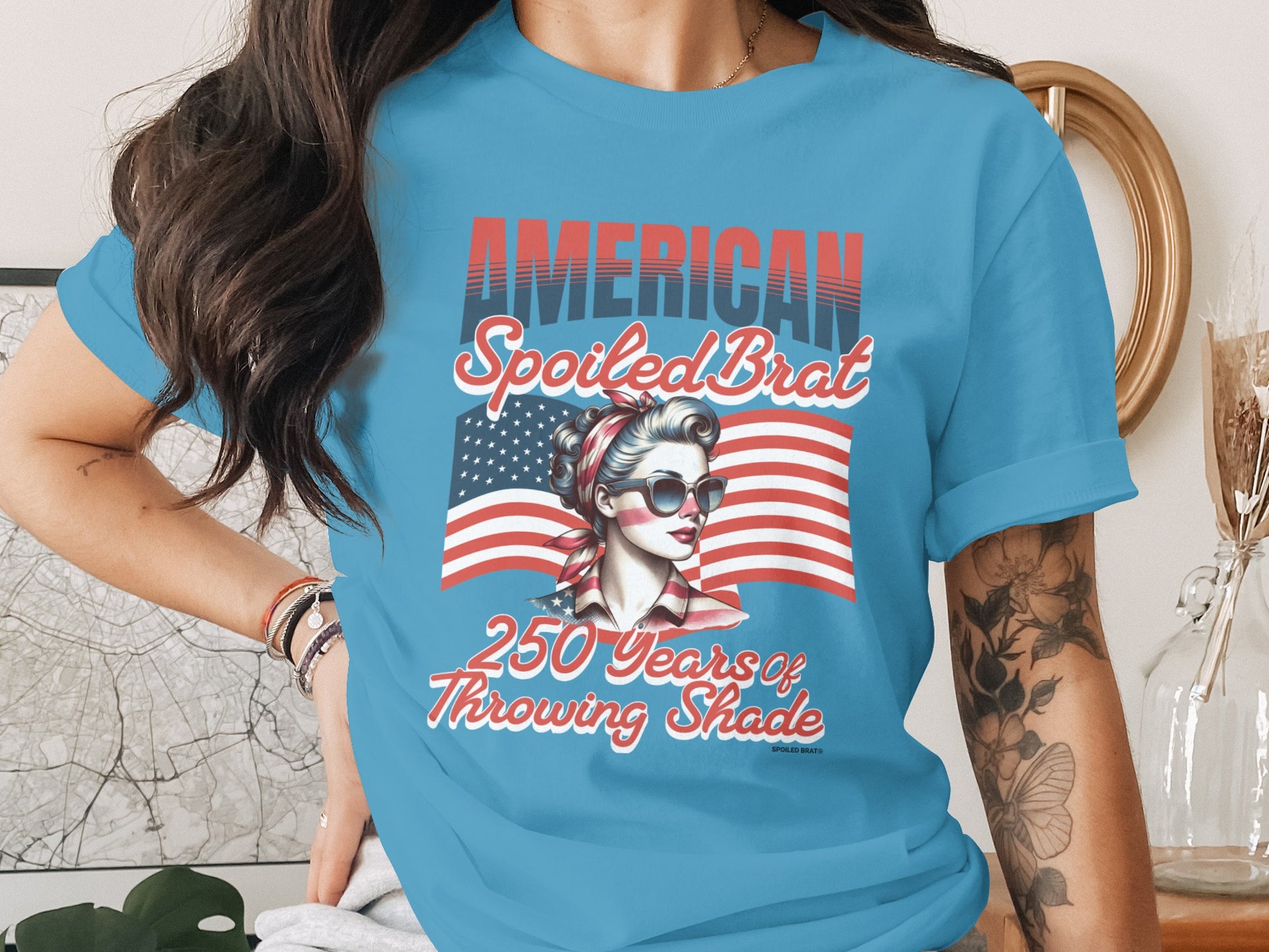 American Spoiled Brat graphic tee with American flag and woman wearing sunglasses.