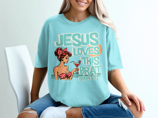 Teal t-shirt with graphic of a pin-up girl and text "JESUS LOVES THIS BRAT (RIGHT?)".