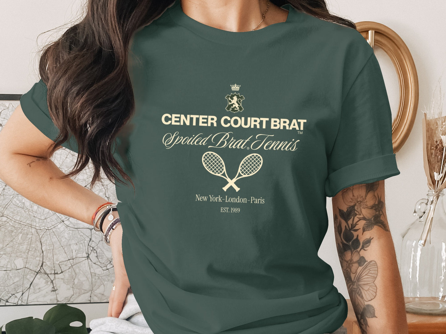 Green t-shirt with text "CENTER COURT BRAT" and tennis rackets.