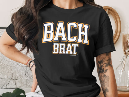 Black t-shirt with white and yellow text reading "BACH BRAT".