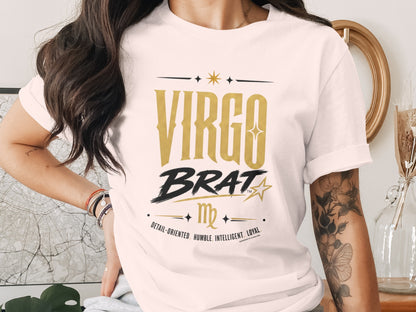 White t-shirt with "Virgo Brat" in gold, black, and text describing Virgo traits.