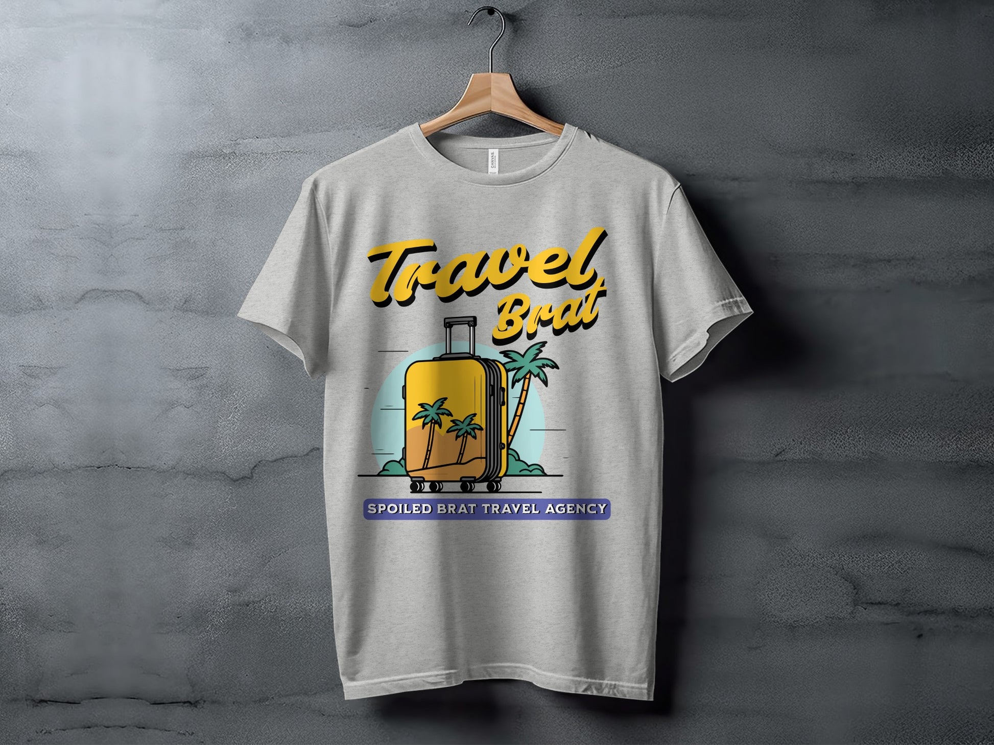 Grey t-shirt with "Travel Brat" and a yellow suitcase with palm trees and "Spoiled Brat Travel Agency".
