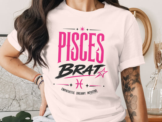 White t-shirt with "PISCES BRAT" text, Pisces symbol, and "EMPATHETIC. DREAMY. INTUITIVE."