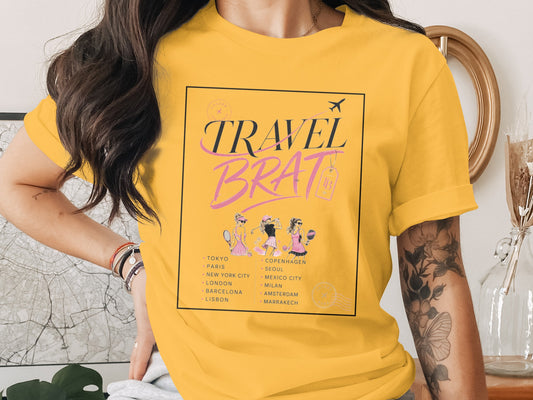 Yellow t-shirt with "Travel Brat" text, travel destinations, and three women.