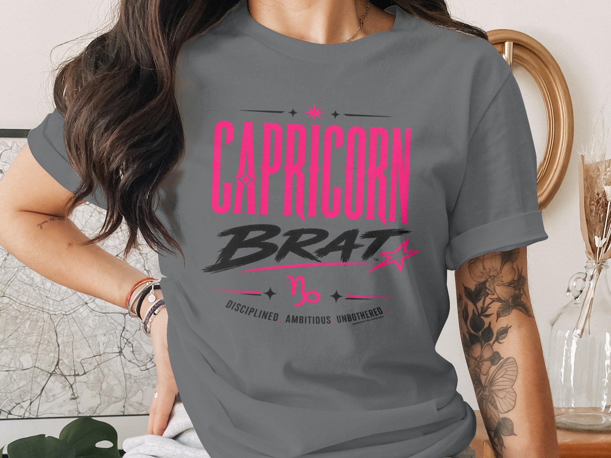 Capricorn Brat graphic tee in charcoal gray with pink text.