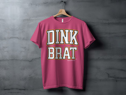 Pink t-shirt with white and yellow text "DINK BRAT" and a small logo.