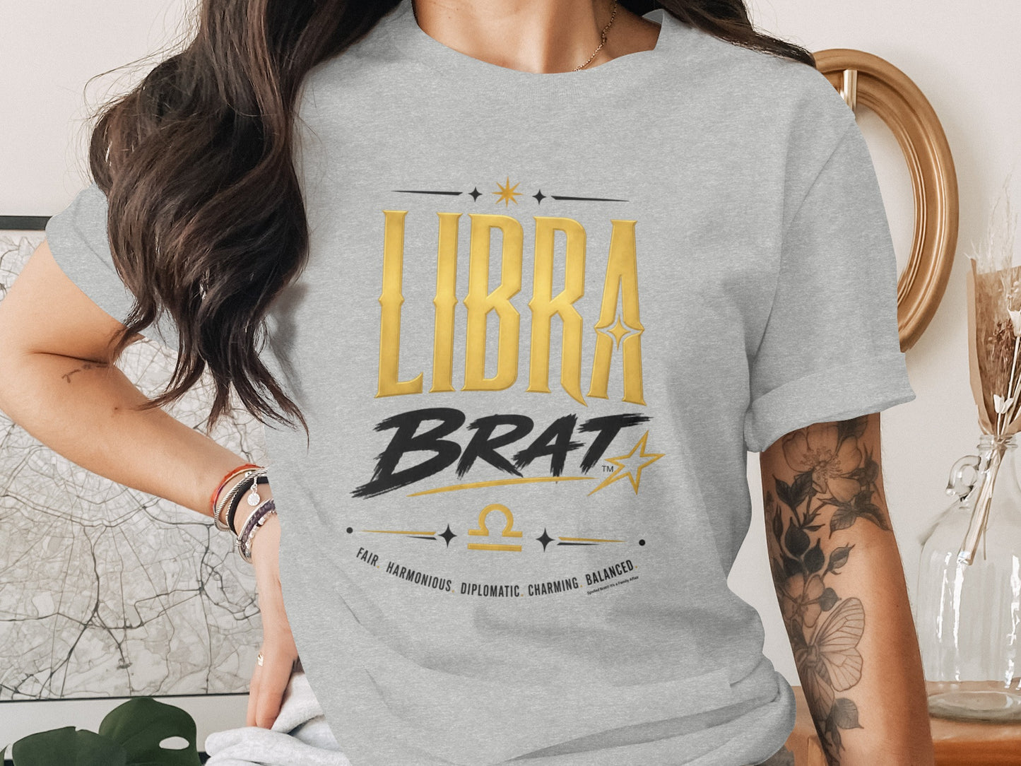 Grey t-shirt with gold "LIBRA BRAT" text, scales, and zodiac traits.