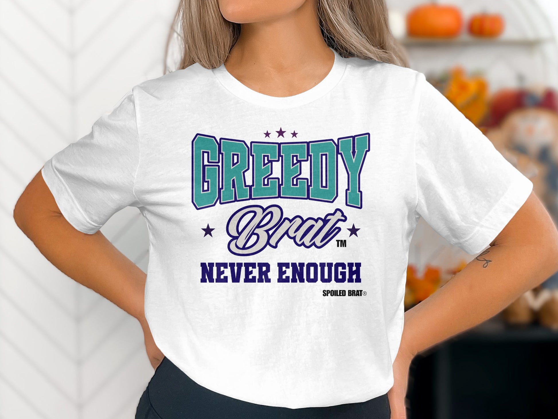 White t-shirt with "GREEDY Brat NEVER ENOUGH" text and Spoiled Brat logo.