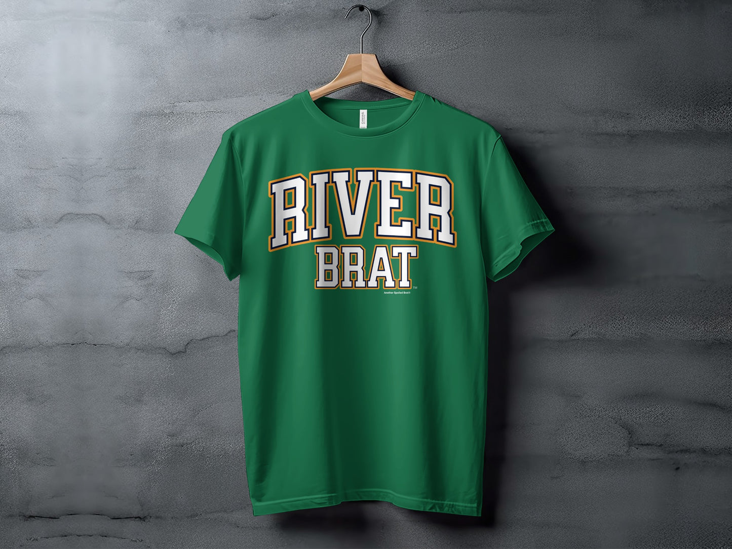 Green t-shirt with white and yellow "RIVER BRAT" text, hanging on a hanger.