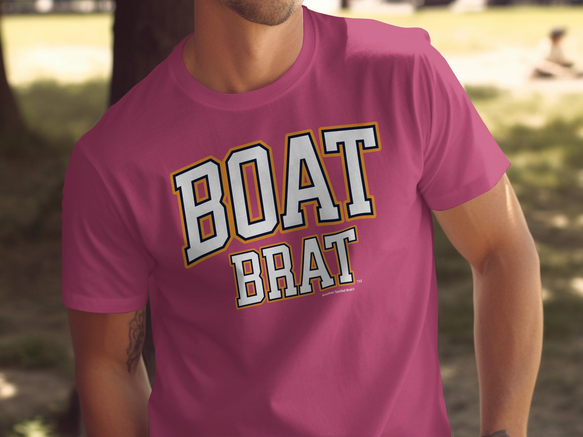 Pink t-shirt with "BOAT BRAT" in white, outlined text with a yellow and navy border.