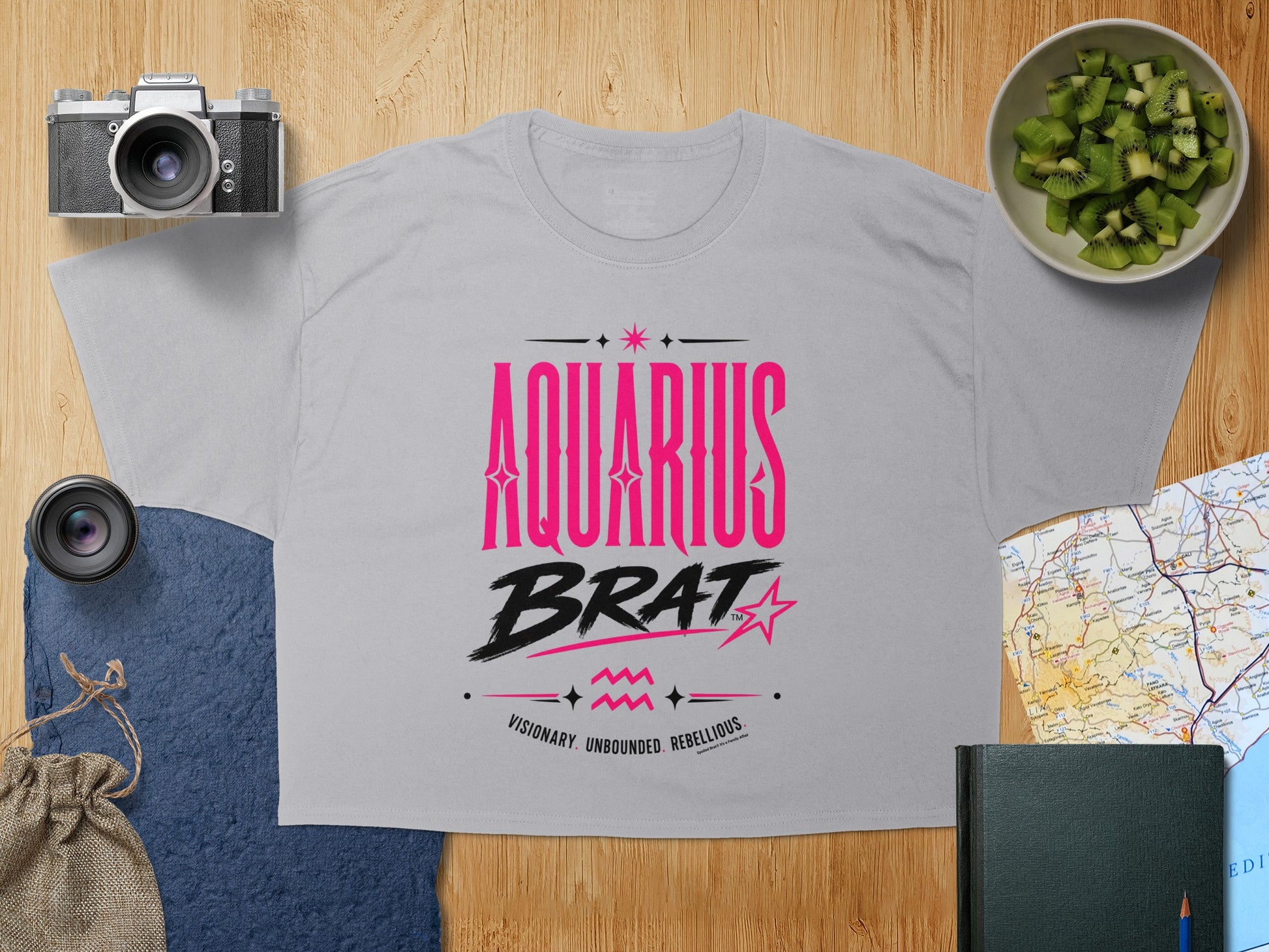 Gray t-shirt with "AQUARIUS BRAT" text, star graphic, and "VISIONARY. UNBOUNDED. REBELLIOUS." tagline.