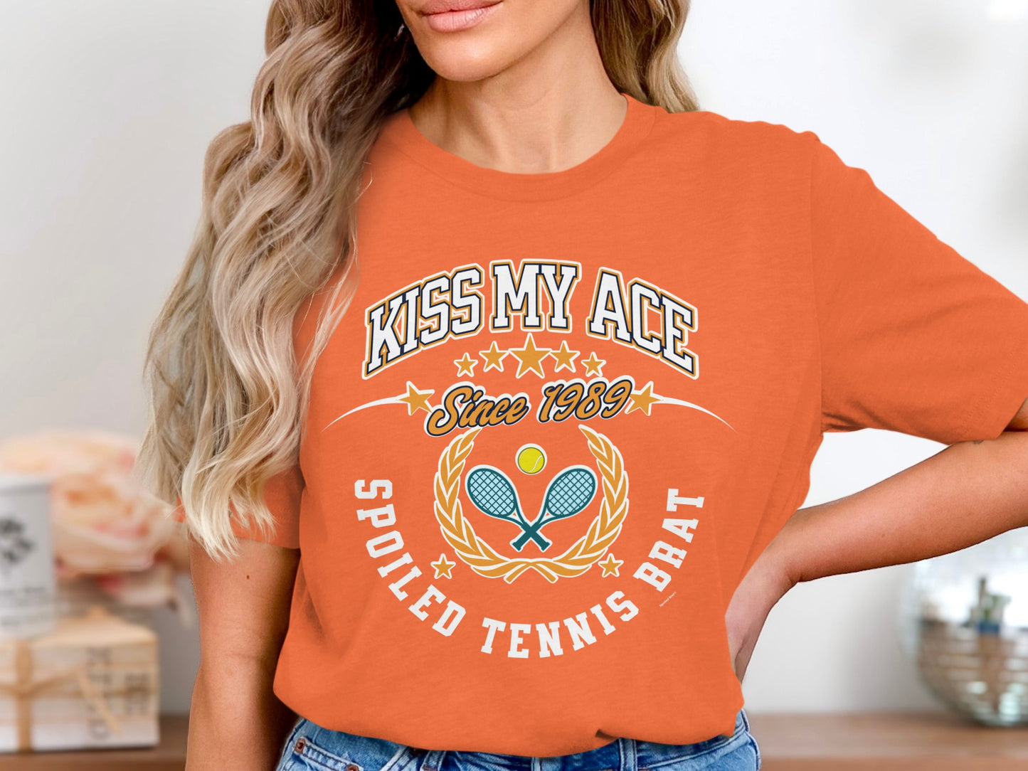 Orange t-shirt with "Kiss My Ace" and tennis graphics.