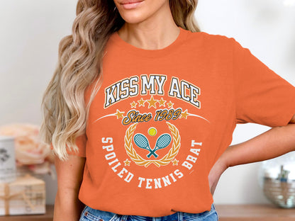 Orange t-shirt with "Kiss My Ace" and tennis graphics.