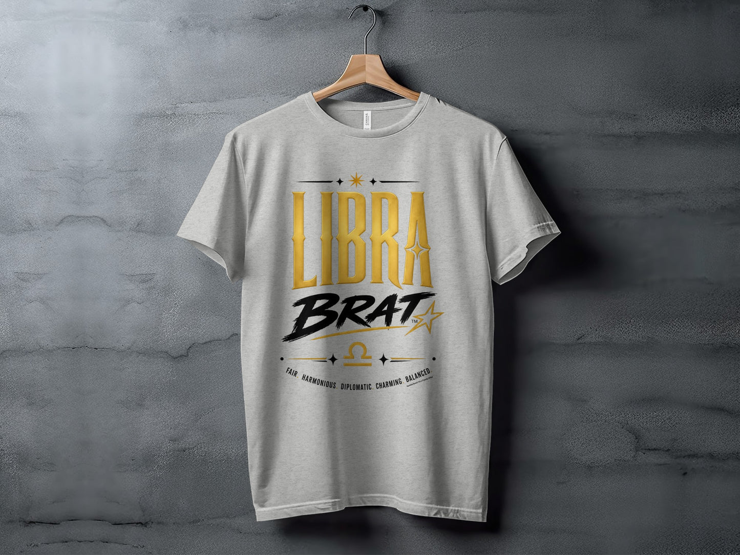 Grey t-shirt with gold "LIBRA BRAT" text and Libra constellation symbol.