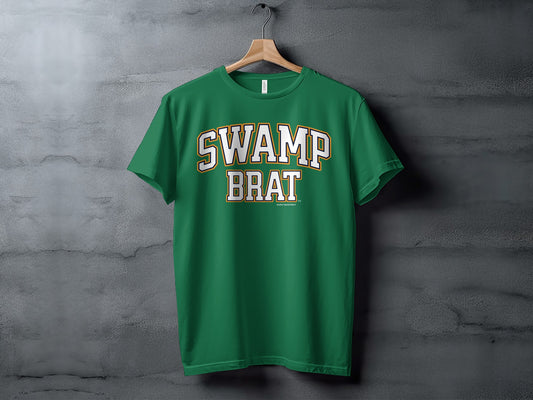 Green t-shirt with white and gold "SWAMP BRAT" text on chest.