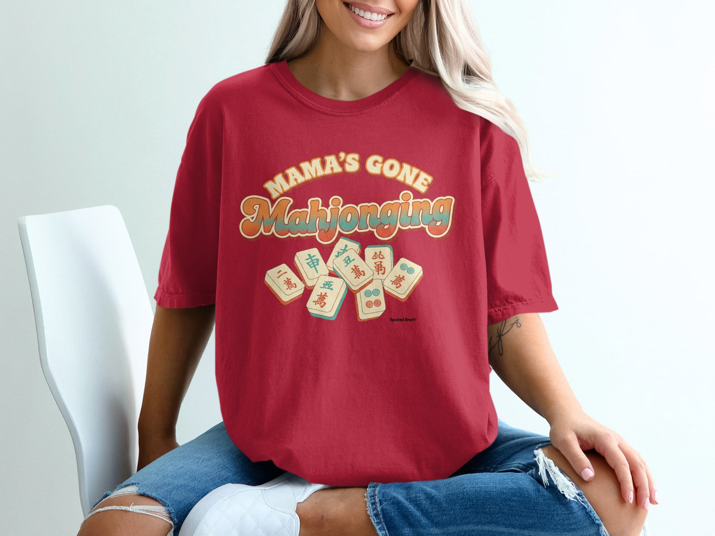 Red t-shirt with "Mama's Gone Mahjong" graphic and mahjong tiles.