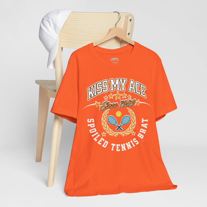 Orange t-shirt with "Kiss My Ace" and tennis graphics.