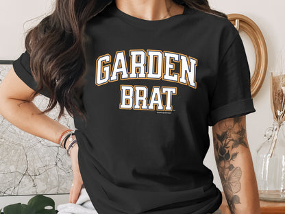 Black t-shirt with "GARDEN BRAT" in white and orange lettering.