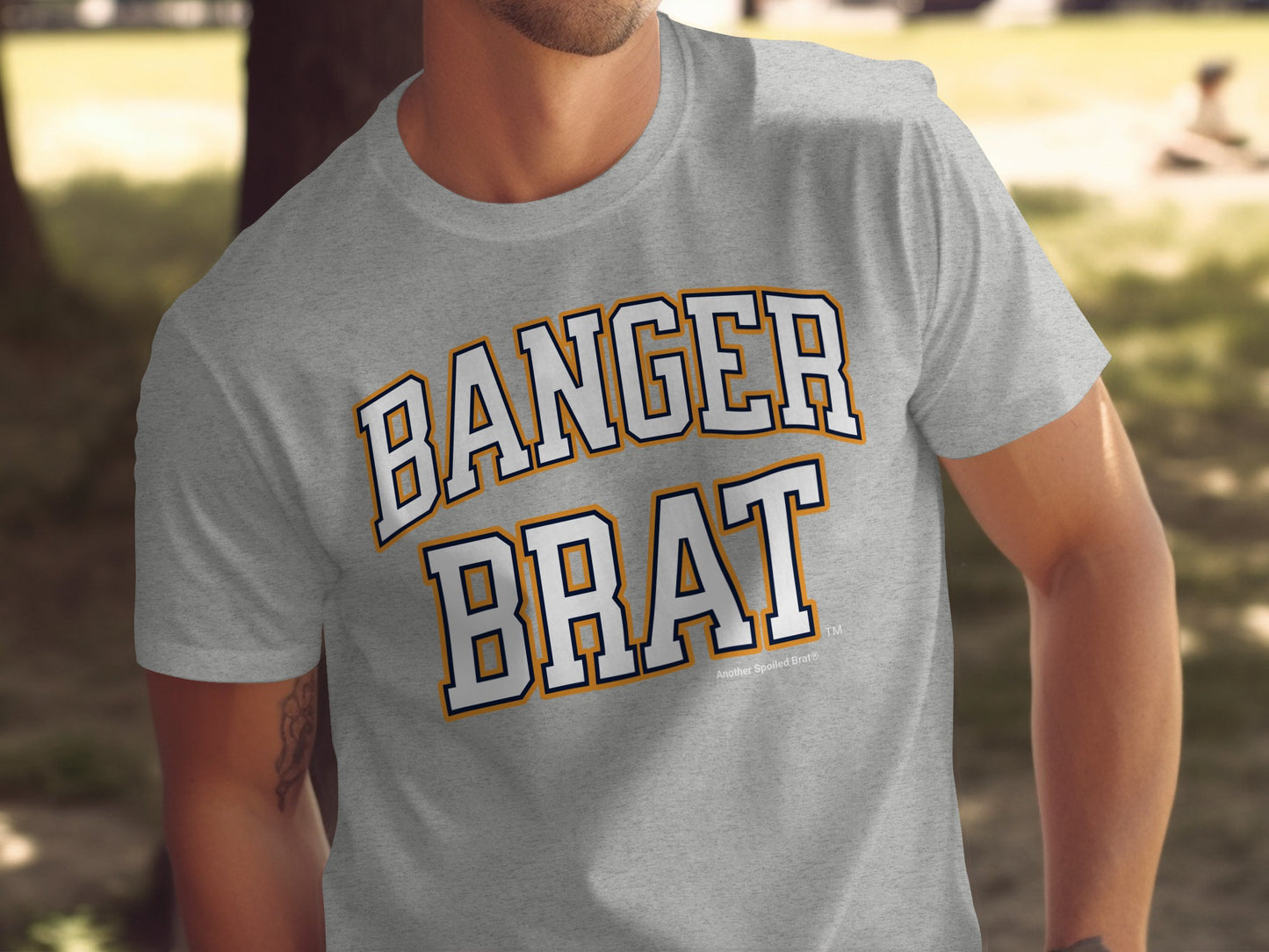 Grey t-shirt with "BANGER BRAT" text in white outlined with navy and orange.