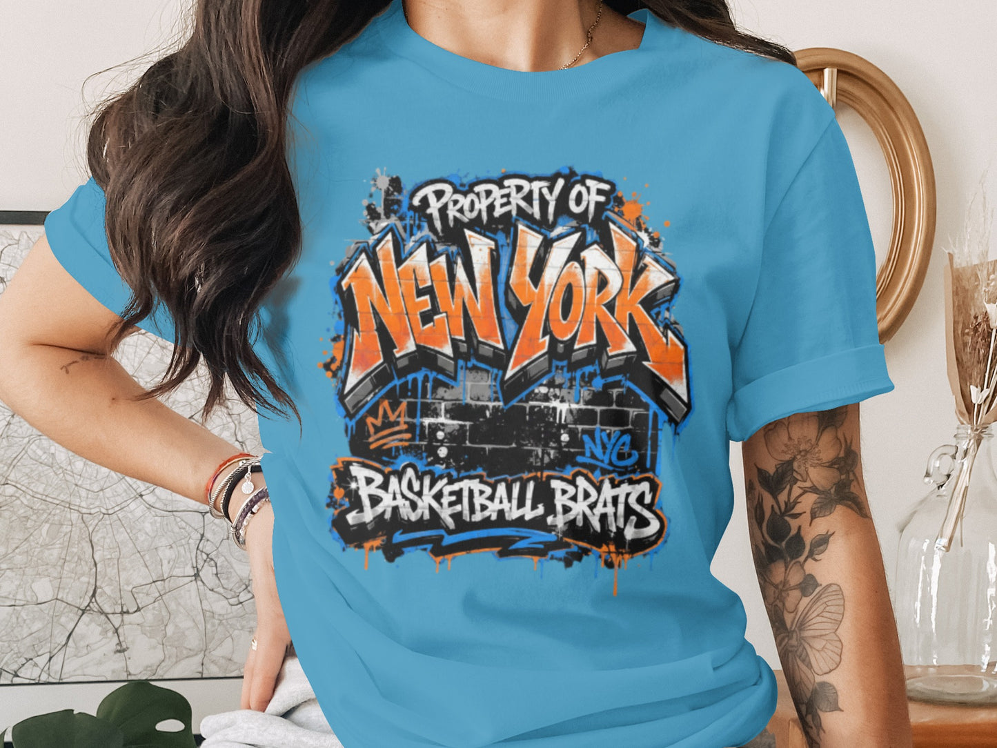 Blue t-shirt with "Property of New York Basketball Brats" graffiti design.