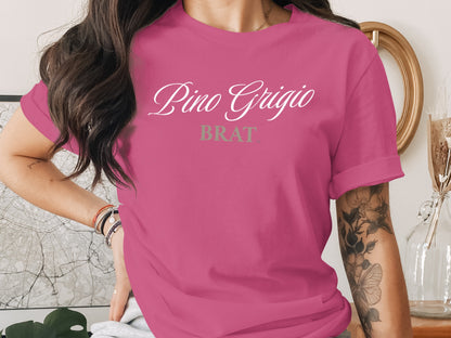 Pink t-shirt with "Pino Grigio BRAT" text in white and gray.