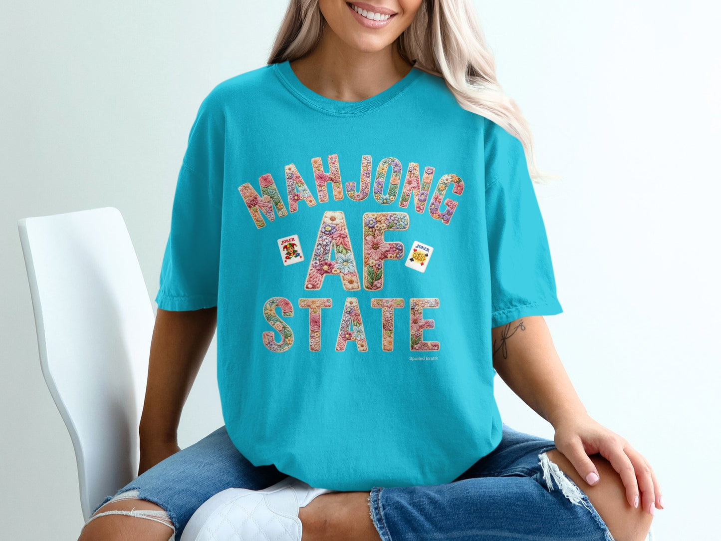 Turquoise t-shirt with "Mahjong AF" in floral letters and playing cards.