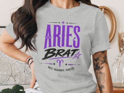 Grey t-shirt with purple "Aries Brat" text, Aries symbol, and "Bold. Passionate. Fearless."