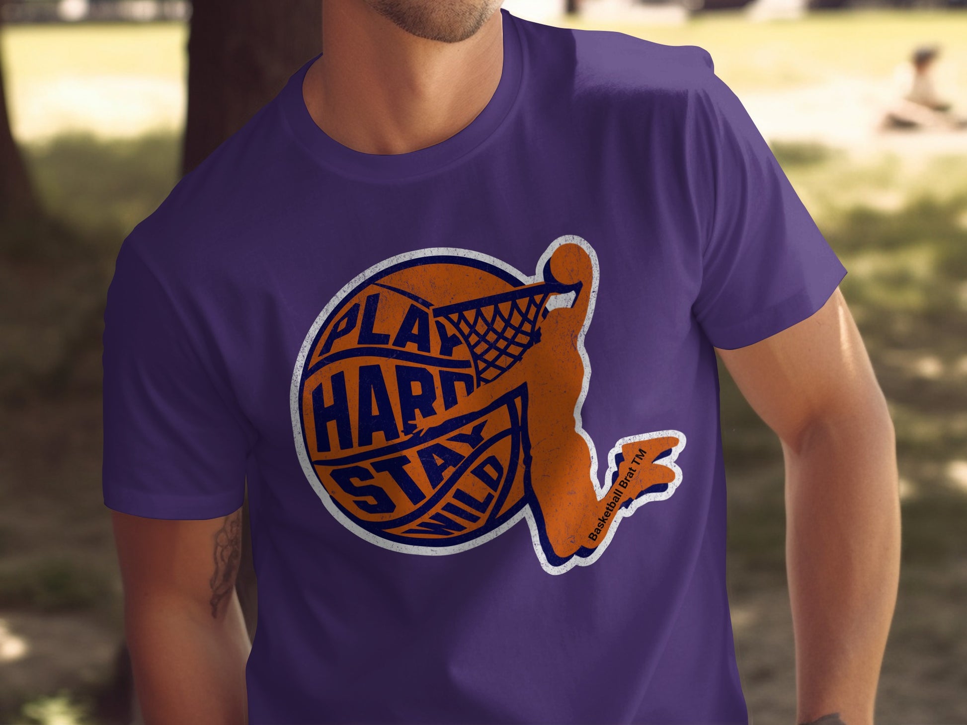 Purple t-shirt with orange basketball player graphic and "Play Hard Stay Wild" text.