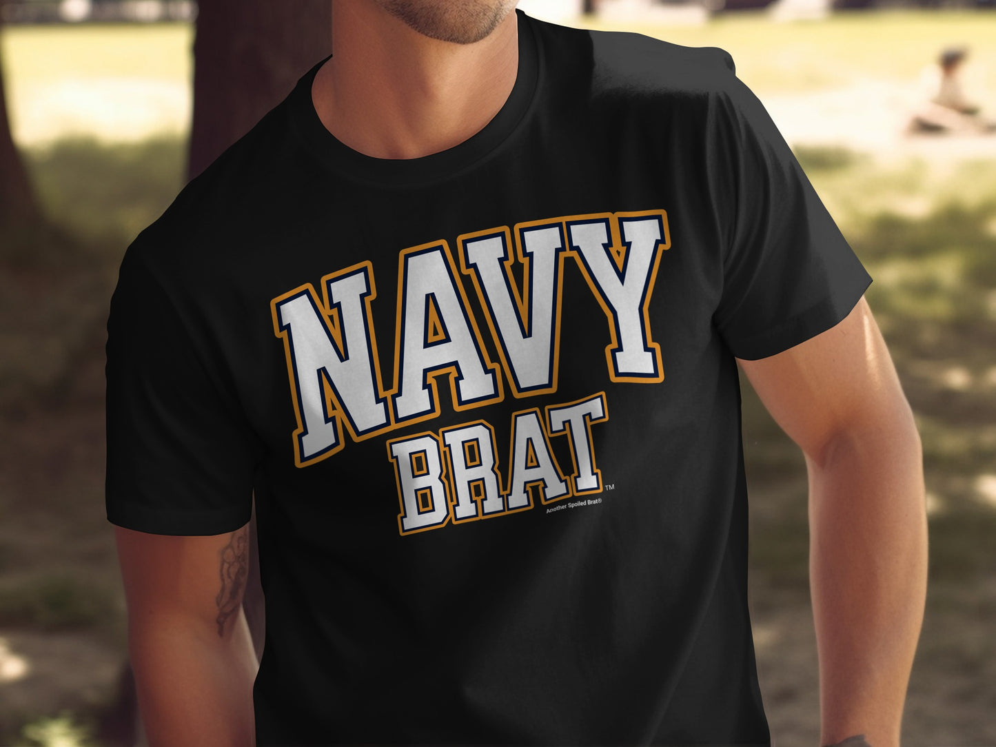 Black t-shirt with "NAVY BRAT" text in white with orange and navy outline.