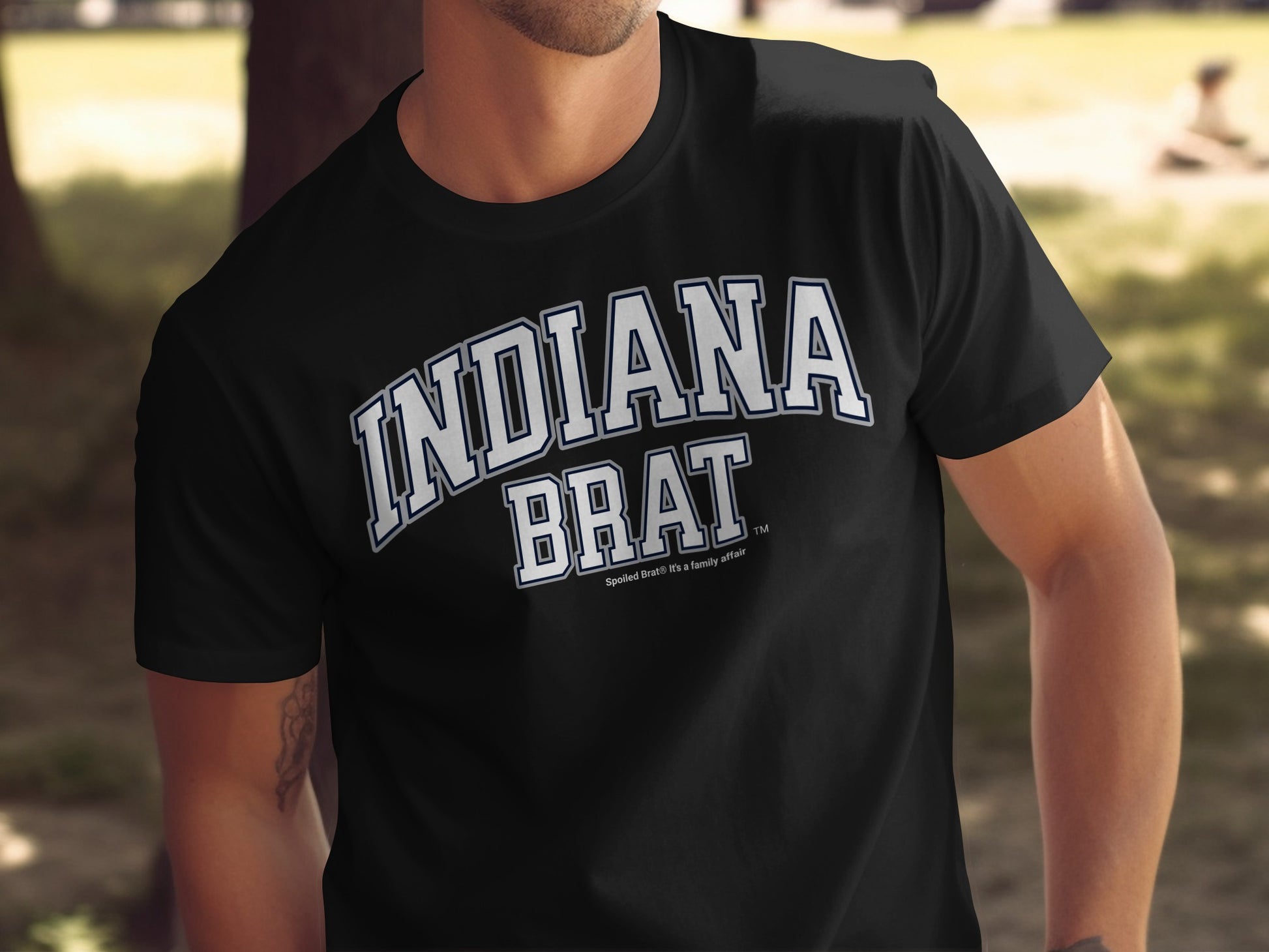 Black t-shirt with "INDIANA BRAT" in white arched lettering.