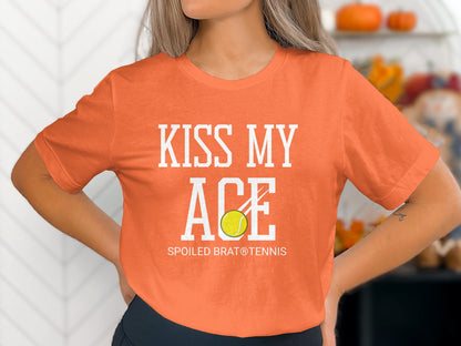 Orange t-shirt with "KISS MY ACE" and tennis ball graphic.