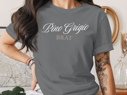 Grey t-shirt with "Pino Grigio BRAT" text in white and beige script.