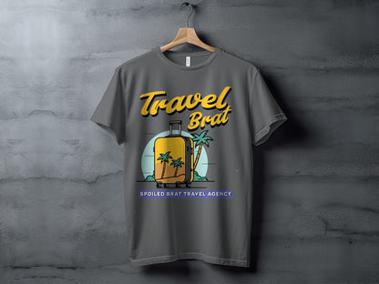 Grey t-shirt with "Travel Brat" and "Spoiled Brat Travel Agency" text and suitcase graphic.
