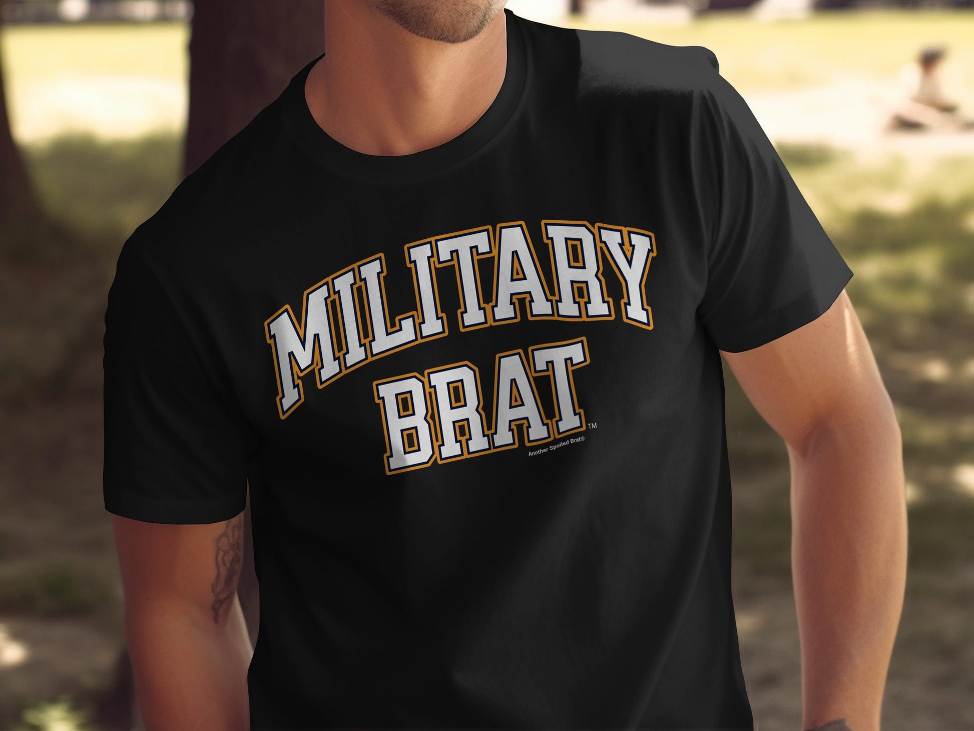 Black t-shirt with "MILITARY BRAT" in white and yellow collegiate lettering.