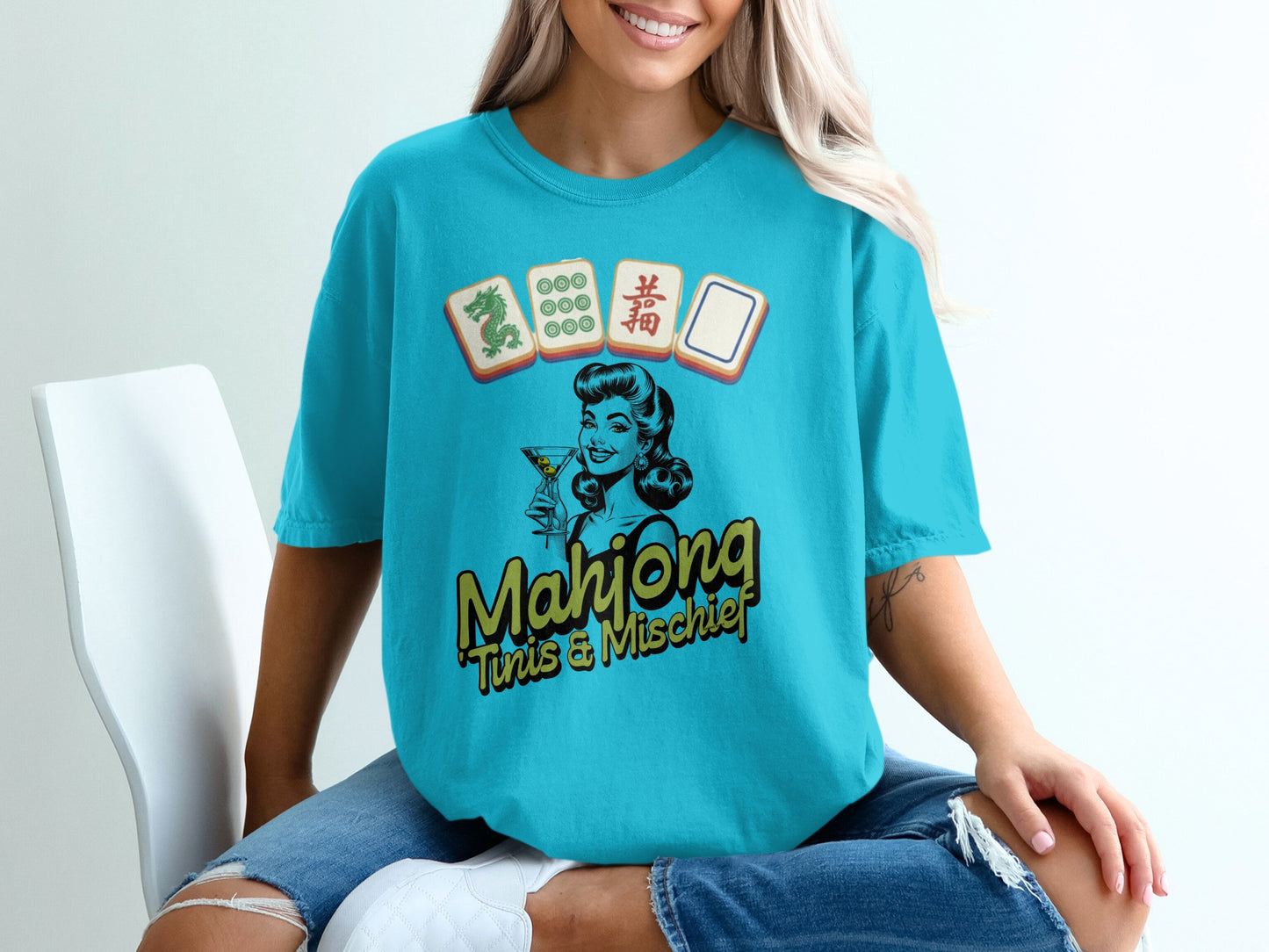 Blue t-shirt with a graphic of a woman and Mahjong tiles, text "Mahjong" and "Fun & Mischief".