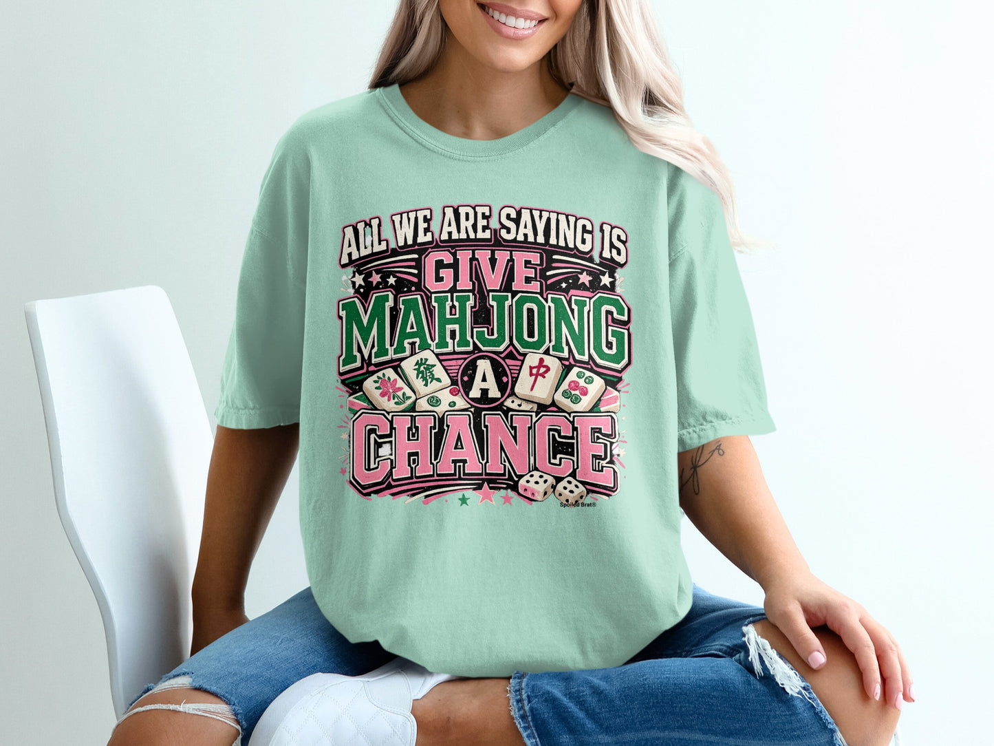 T-shirt with text "All we are saying is give Mahjong a chance" and mahjong tiles.