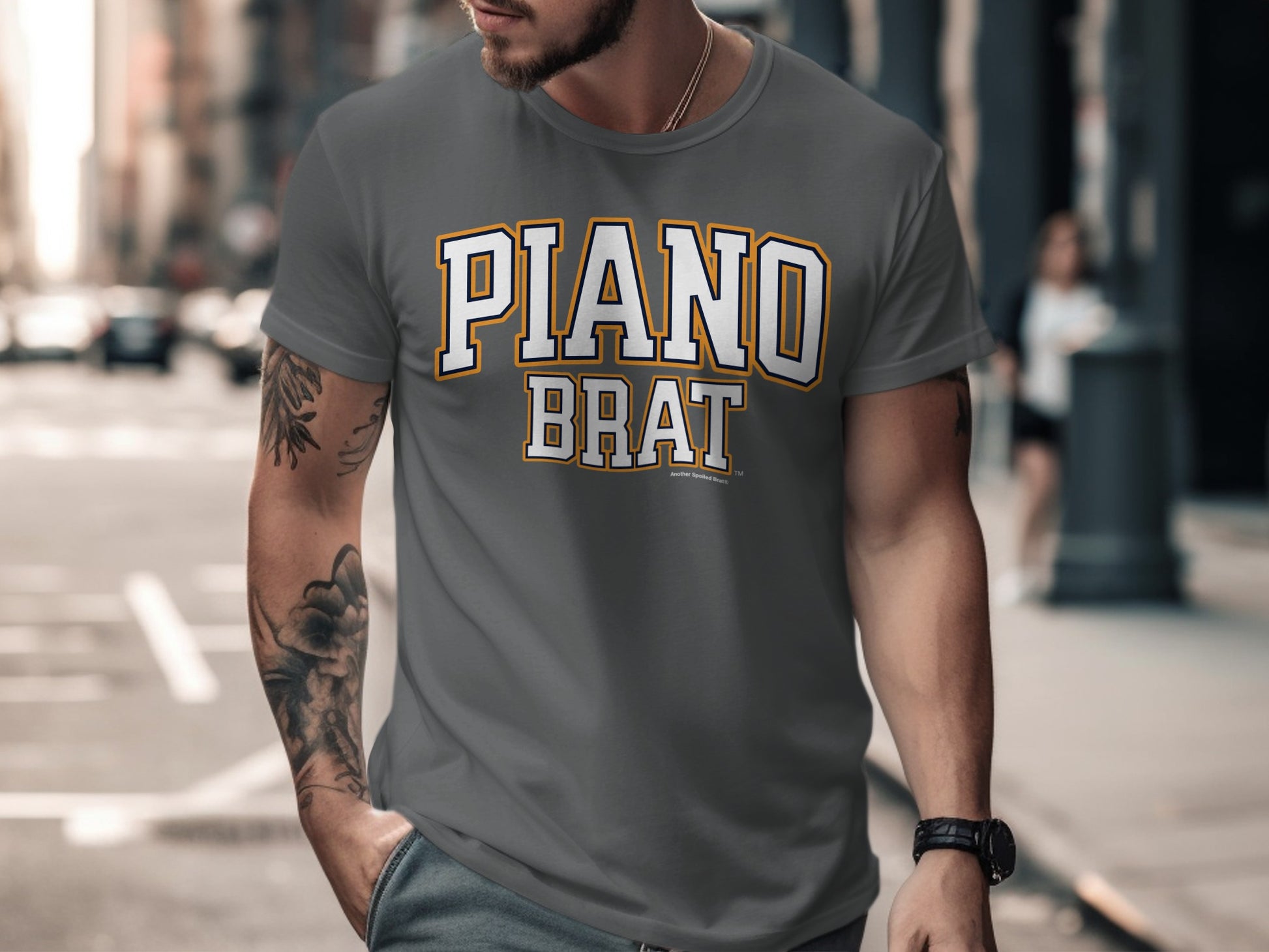 Man wearing gray t-shirt with "PIANO BRAT" text in white and yellow outlined letters.