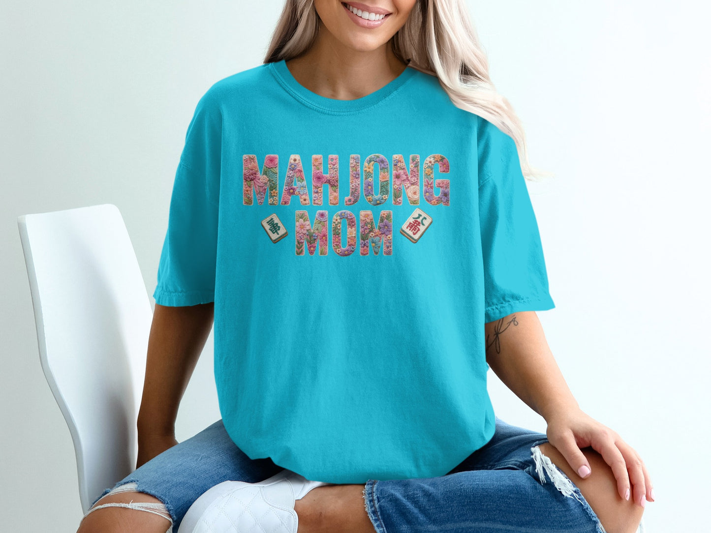 Turquoise t-shirt with "Mahjong Mom" in floral letters and Mahjong tiles.