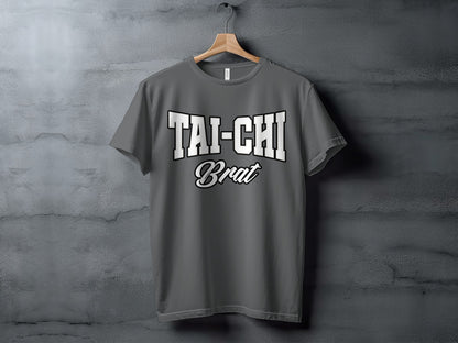 Gray t-shirt with "TAI-CHI Brat" text graphic on speckled gray background.