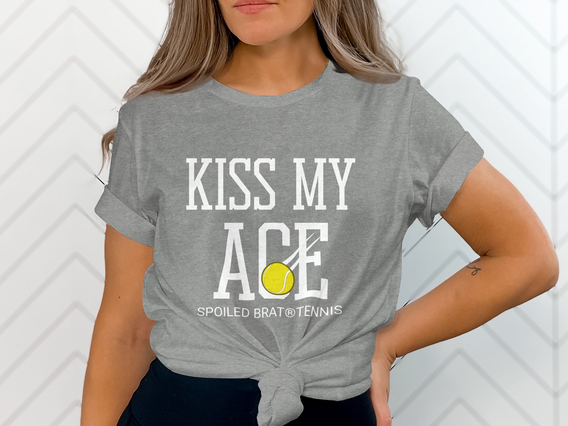 Gray t-shirt with "KISS MY ACE" and a tennis ball, "SPOILED BRAT® TENNIS" below.