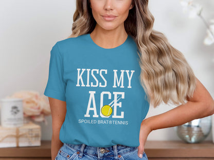 Blue t-shirt with white text "KISS MY ACE SPOILED BRAT® TENNIS" and a tennis ball.