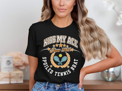 Black t-shirt with "KISS MY ACE SINCE 1989 SPOILED TENNIS BRAT" text.