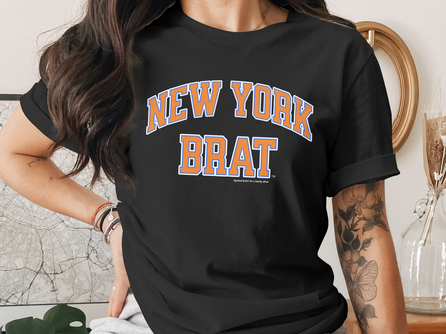 Black t-shirt with "NEW YORK BRAT" in orange and blue collegiate lettering.