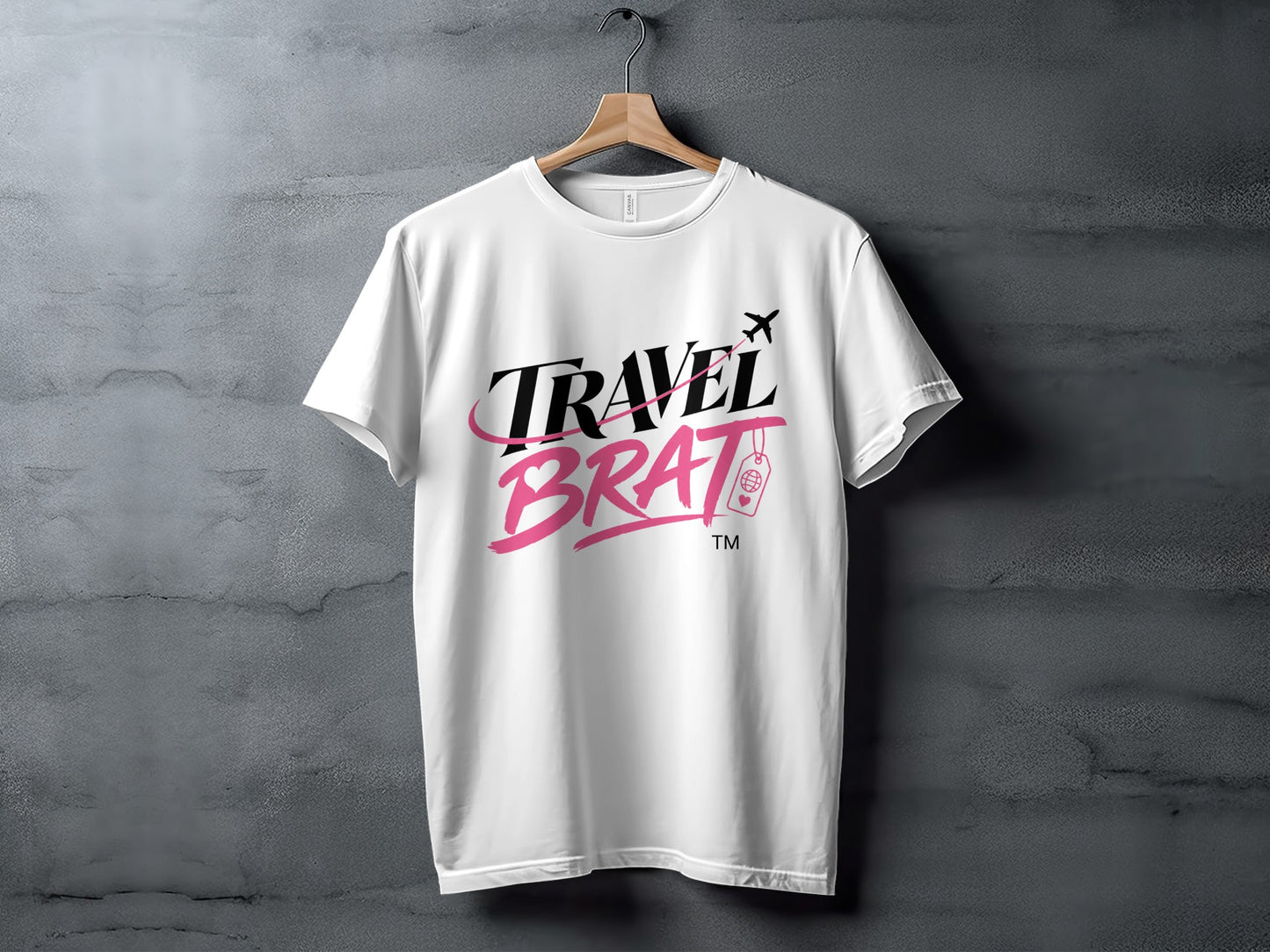 White t-shirt with "TRAVEL BRAT" text, airplane, and suitcase graphic.
